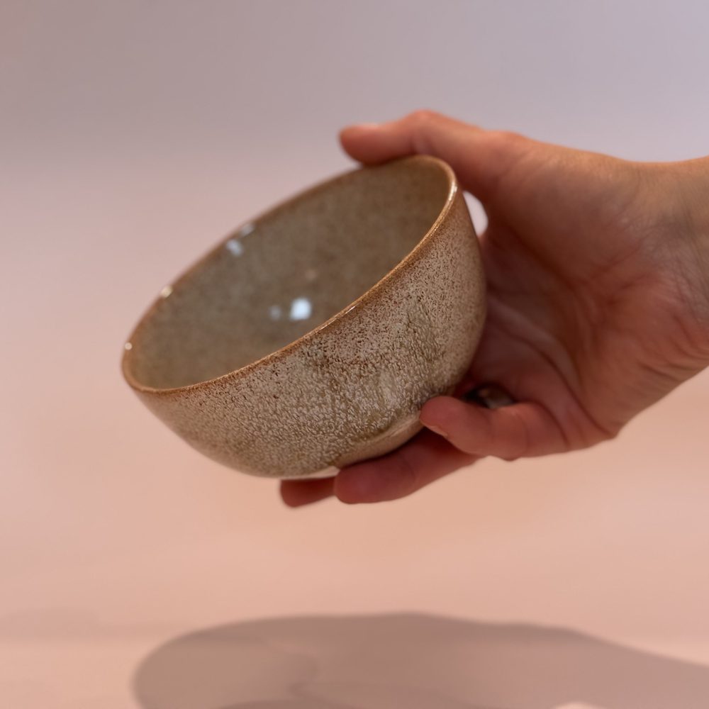 Speckled oatmeal bowl held in a hand
